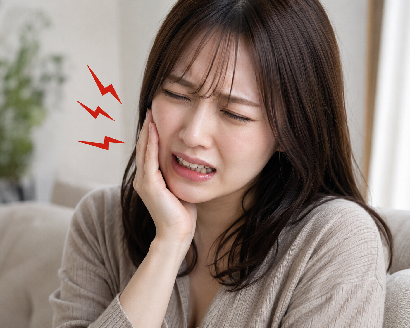 頬に手を当てて歯の痛みに顔をしかめる女性のイメージ
